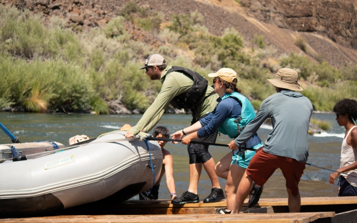 a group of students pull a raft onto a trailer during a gap year semester with outward bound